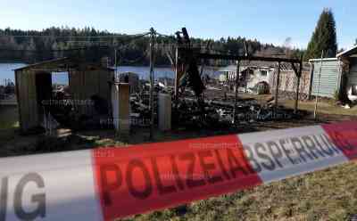 20 Gartenlauben brennen vollständig nieder: Brandruinen am Tag, Eigentümer stehen fassungslos vor ihren verkohlten Gartenlauben: Kriminalpolizei sichert Spuren, Gebiet weiträumig abgesperrt
