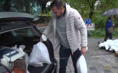 (Hochwasser, stark) Hochwasseralarm in Wangen (Allgäu): Stadt bereitet sich auf Hochwasser vor, Menschen sichern sich Sandsäcke – teilweise im Kofferraum eines Autos, ältere Dame schleppt Sandsäcke: Obere Arge wird zum reißenden Fluss, wenig Platz unter Brücken, Wasser strömt auf B 32