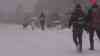 Schneesturm - Winter im Harz: Wettersturz bringt mehrere Zentimeter Neuschnee und einen Schneesturm, Geburtstagskind feiert Geburtstag im Schnee und Sturm auf dem Brocken (on tape): Enorme Wettergegensätze zum Vortag, anstatt Frühling nun – 8 °C starker Schneefall und Sturm, Menschen laufen im Schneesturm
