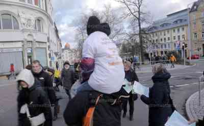 Protest gegen Impfpflicht: Kind wird T-Shirt mit Schriftzügen gegen Impfpflicht während der Demo angezogen (on tape), Kind wird als Protestmittel regelrecht vorgeführt, hunderte Menschen demonstrieren in Freiberg und vor dem Landratsamt: Auch Reichsbürger und Querdenker nutzen Gelegenheit zum Protest, Polizei sichert Aufzug und Versammlung ab