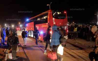 Ukrainekrieg – Flüchtlingen frieren in eisiger Kälte: Feuertonnen, Lagerfeuer oder Heizpilze bringen etwas Wärme, hunderte Flüchtlinge warten mit Kindern auf Busse bis tief in die Nacht hinein, Busse fahren im Sekundentakt: Kinder in Decken eingehüllt und schlafen in den Armen der Geschwister, viele Flüchtlinge warten auf Busse, Polizei und Feuerwehr müssen koordinieren