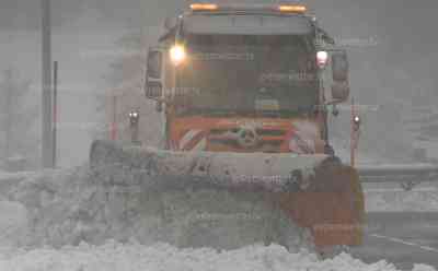 Unwettertief in Italien – viel Neuschnee am Brenner: Winterdienst auf der Brennerautobahn im Dauereinsatz, 20 cm Neuschnee in wenigen Stunden gefallen, schlechte Sicht und dichtes Schneetreiben: Winterdienst gelingt es Brennerpass befahrbar zu halten, Menschen mit Regenschirmen im Schneetreiben