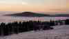 Wintermärchen im Erzgebirge – atemberaubender Wintersonnenuntergang: Wintersonne geht über Nebelmeer unter, Landschaft um den Fichtelberg zeigt sich tiefwinterlich: Zeitraffer vom Sonnenuntergang über dem Nebelmeer, tolle blaue Stunde nach Sonnenuntergang