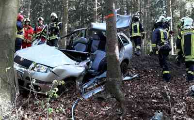 Schwerer Baumcrash und Auffahrunfall halten Feuerwehr auf Trapp– Fahrer über 30 Minuten eingeklemmt: Feuerwehr befreit Fahrer mit hydraulischem Rettungsgerät, Fahrer kommt schwer verletzt ins Krankenhaus: Feuerwehr muss Tür, Dach mit schwerem Rettungsgerät entfernen, aufwändige Rettung