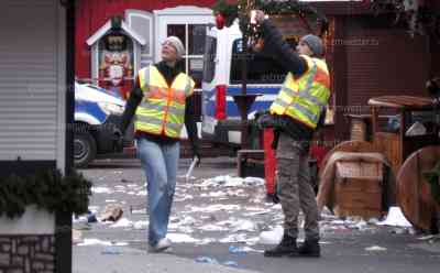 Anschlag in Magdeburg, Stadt trauert: Ermittler sichern immer noch spuren, dutzende Polizeibeamte sichern Weihnachtsmarkt, Menschen mit Tränen in den Augen, Blumenmeer vor Johanniskirche, blutverschmierte Beatmungsmaske und Ersthelfergegenstände am Straßenrand: Menschen legen Blumen und Kerzen nieder, Fassungslosigkeit in Magdeburg